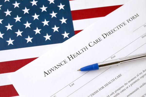 Advance health care directive blank form and blue pen on United States flag close up